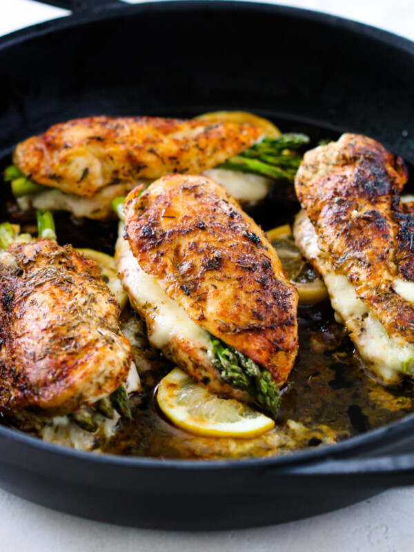 Chicken in a skillet stuffed with asparagus.