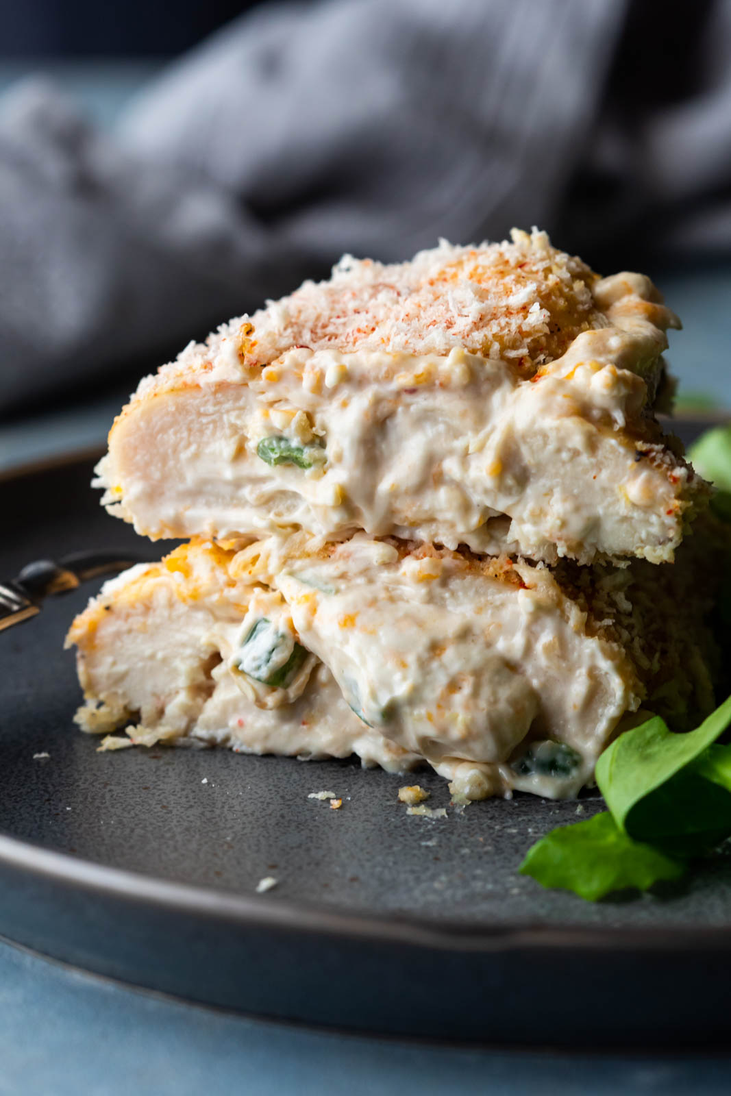 Jalapeno popper stuffed chicken sliced in half with filling and cheese oozing out