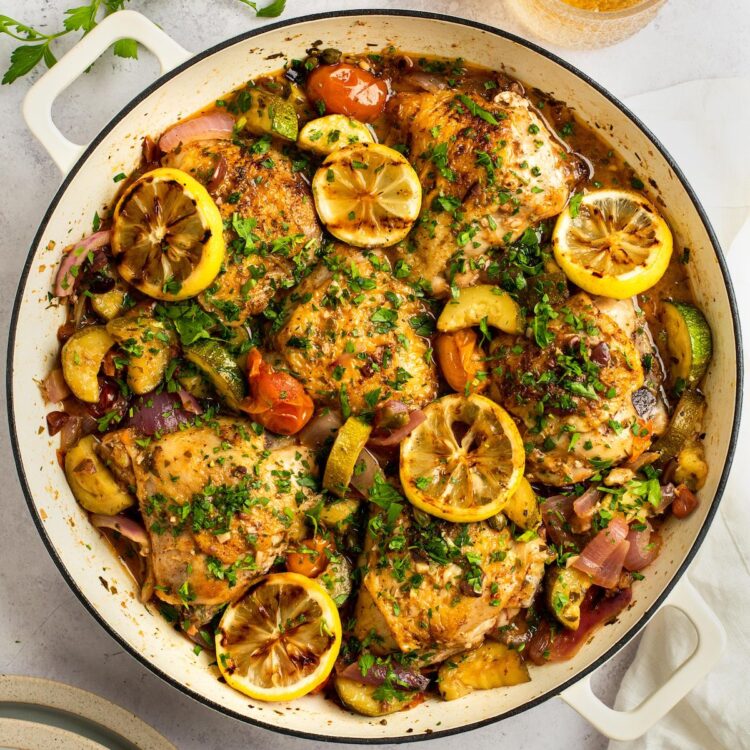 Mediterranean Chicken in a large pot with lemon slices.
