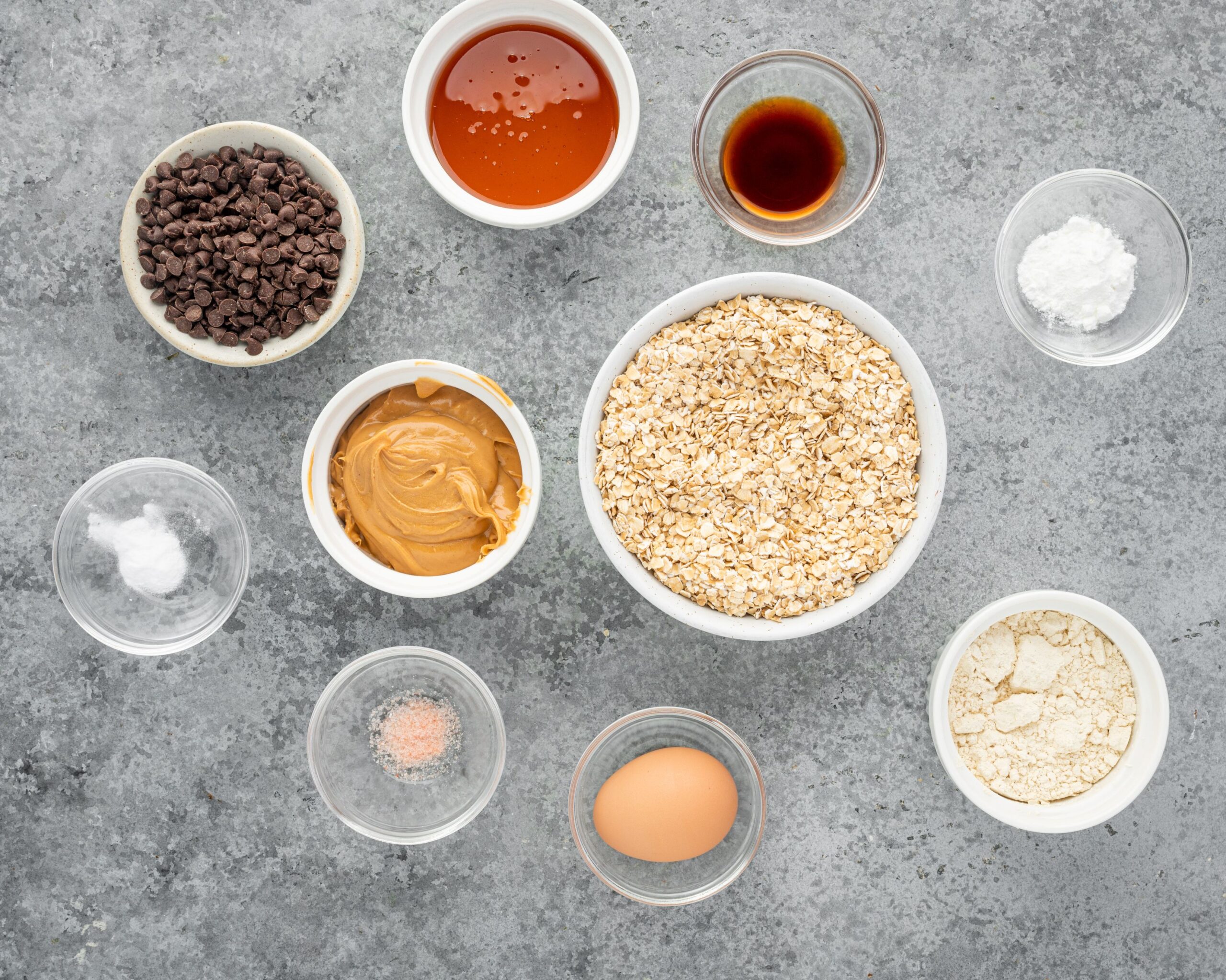 Ingredients for making oatmeal protein cookies divided into small bowls.