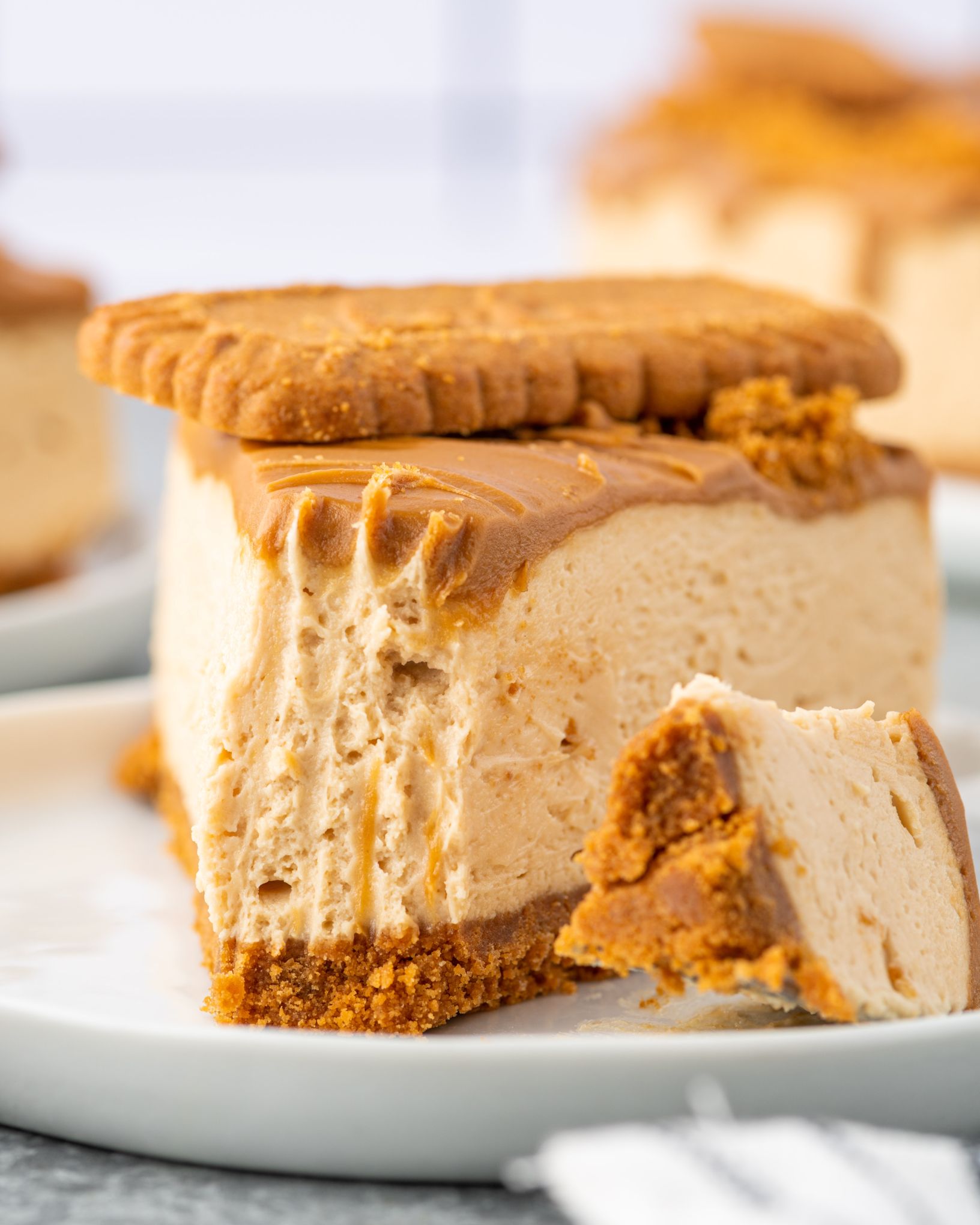 Biscoff Cheesecake topped with a cookie on a white plate.