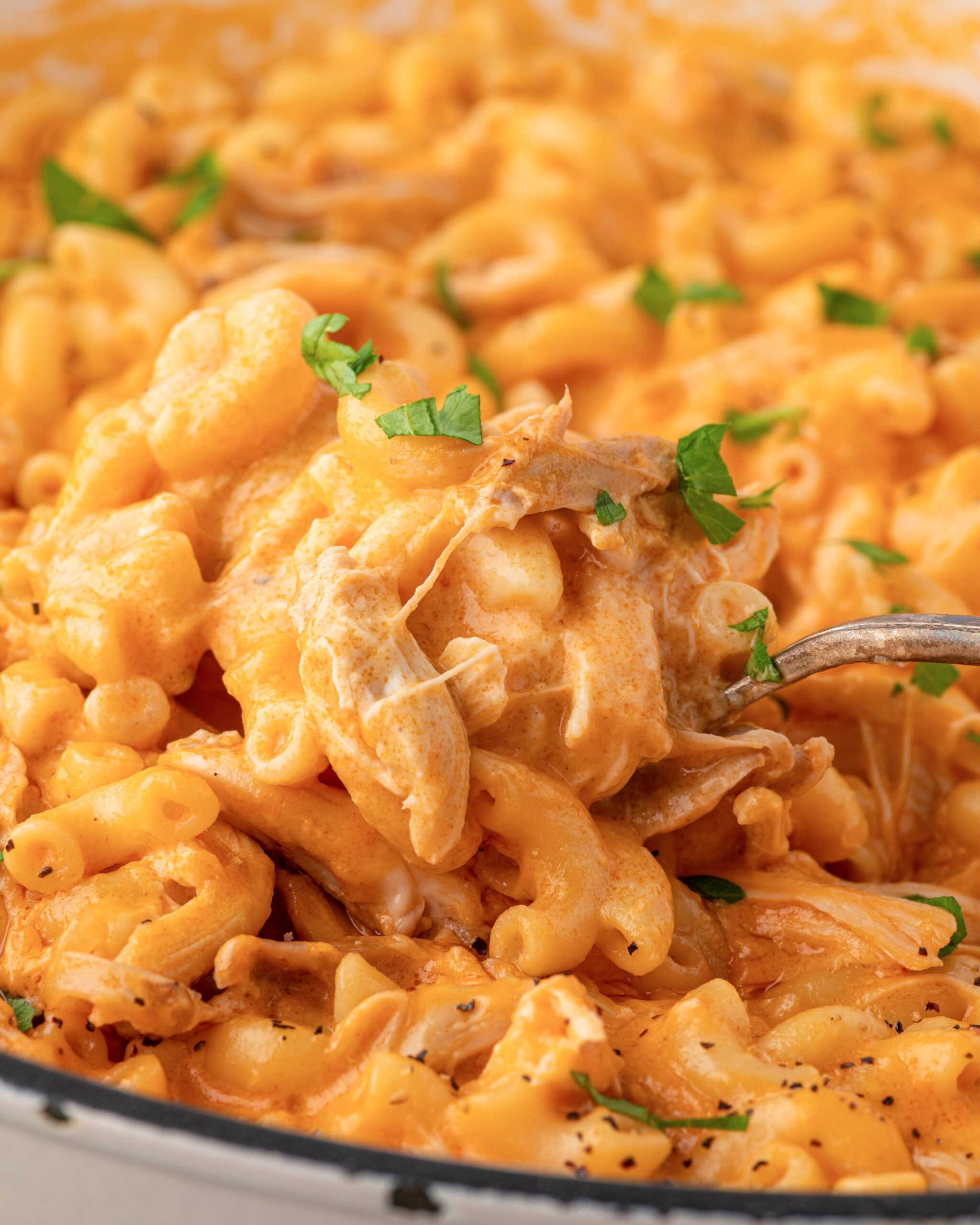 Spoon dishing out buffalo chicken Mac and cheese.