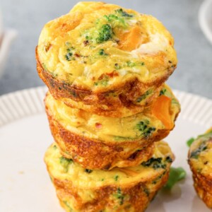 Three egg muffins stacked on a plate.