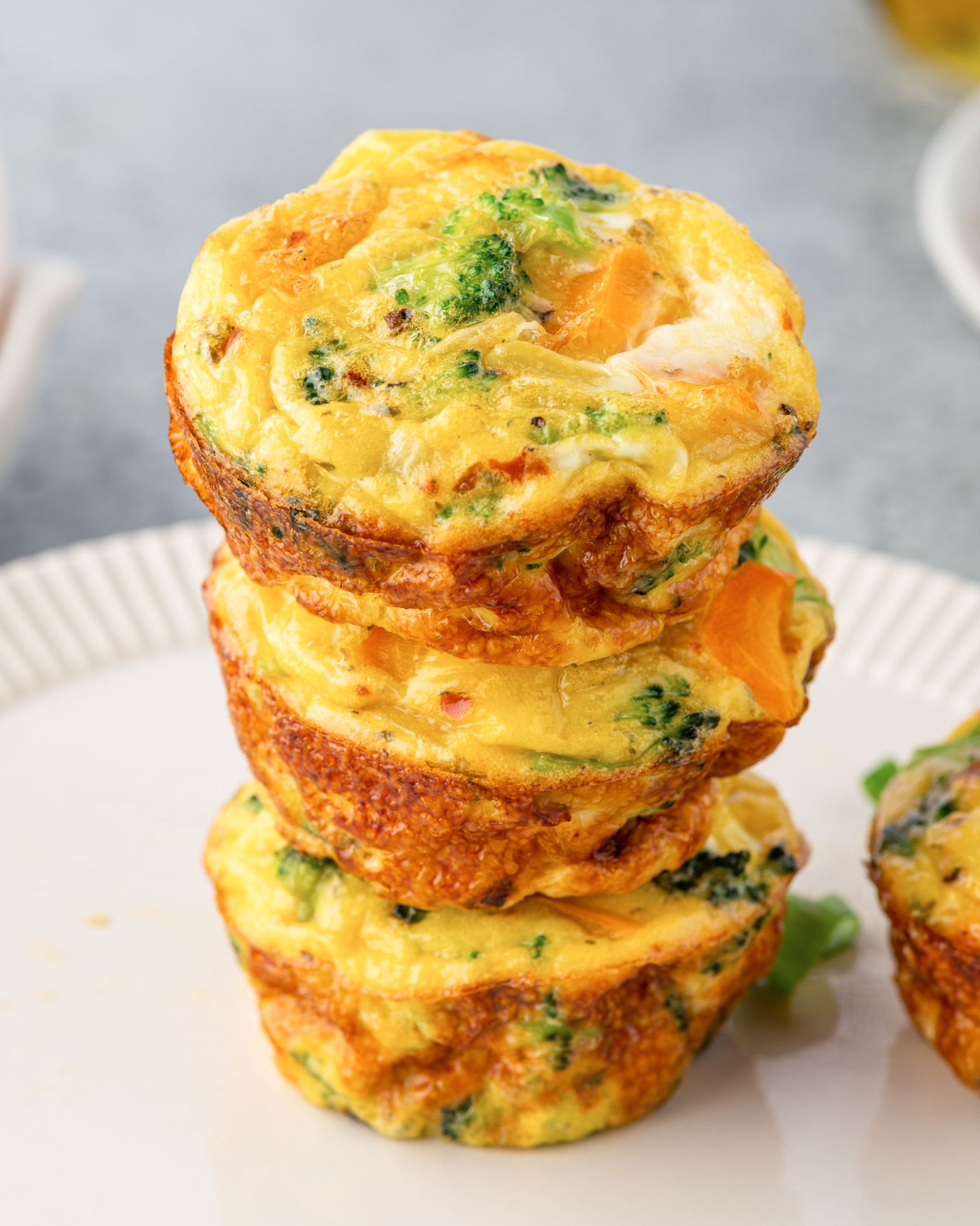 Three egg muffins stacked on a plate.