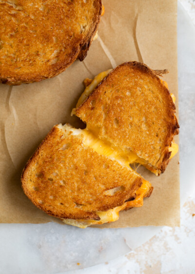 Cheesy grilled cheese sandwich on parchment paper.