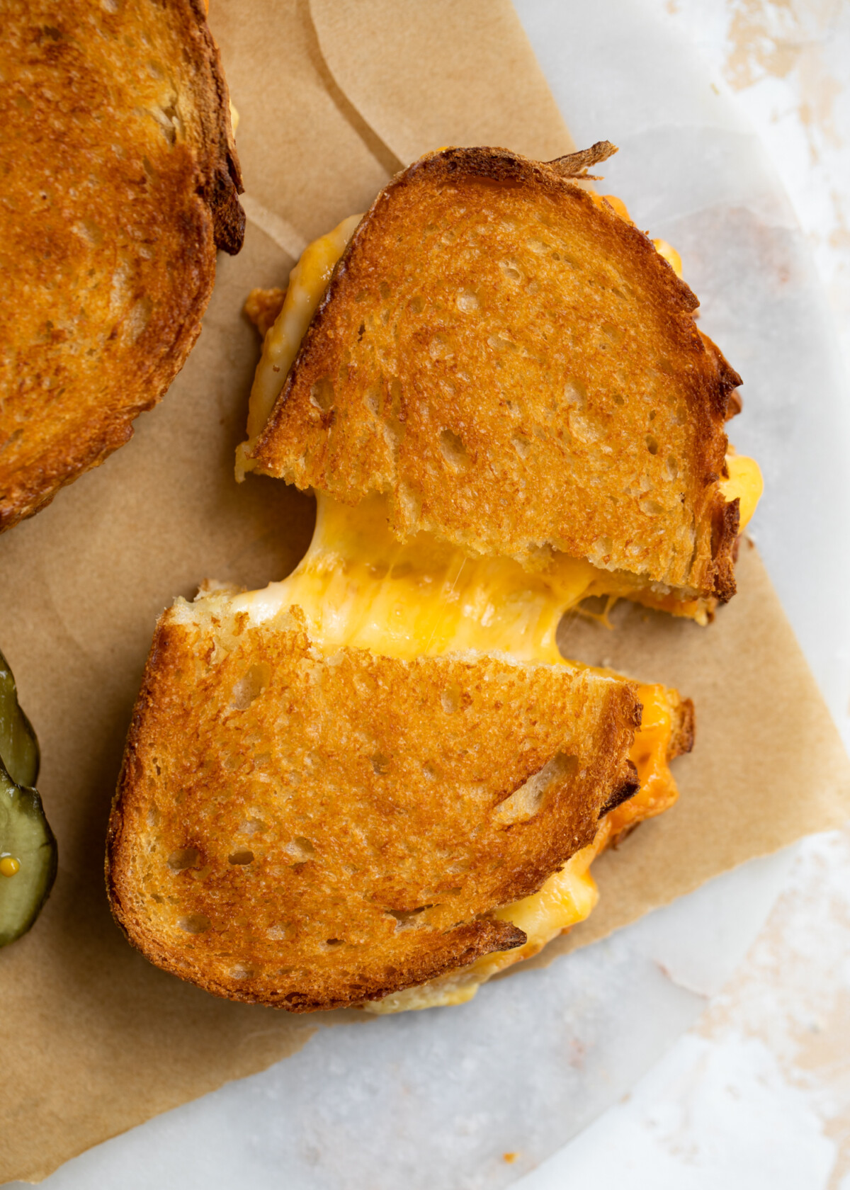 Air fryer grilled cheese cut in half with the cheese pulling.