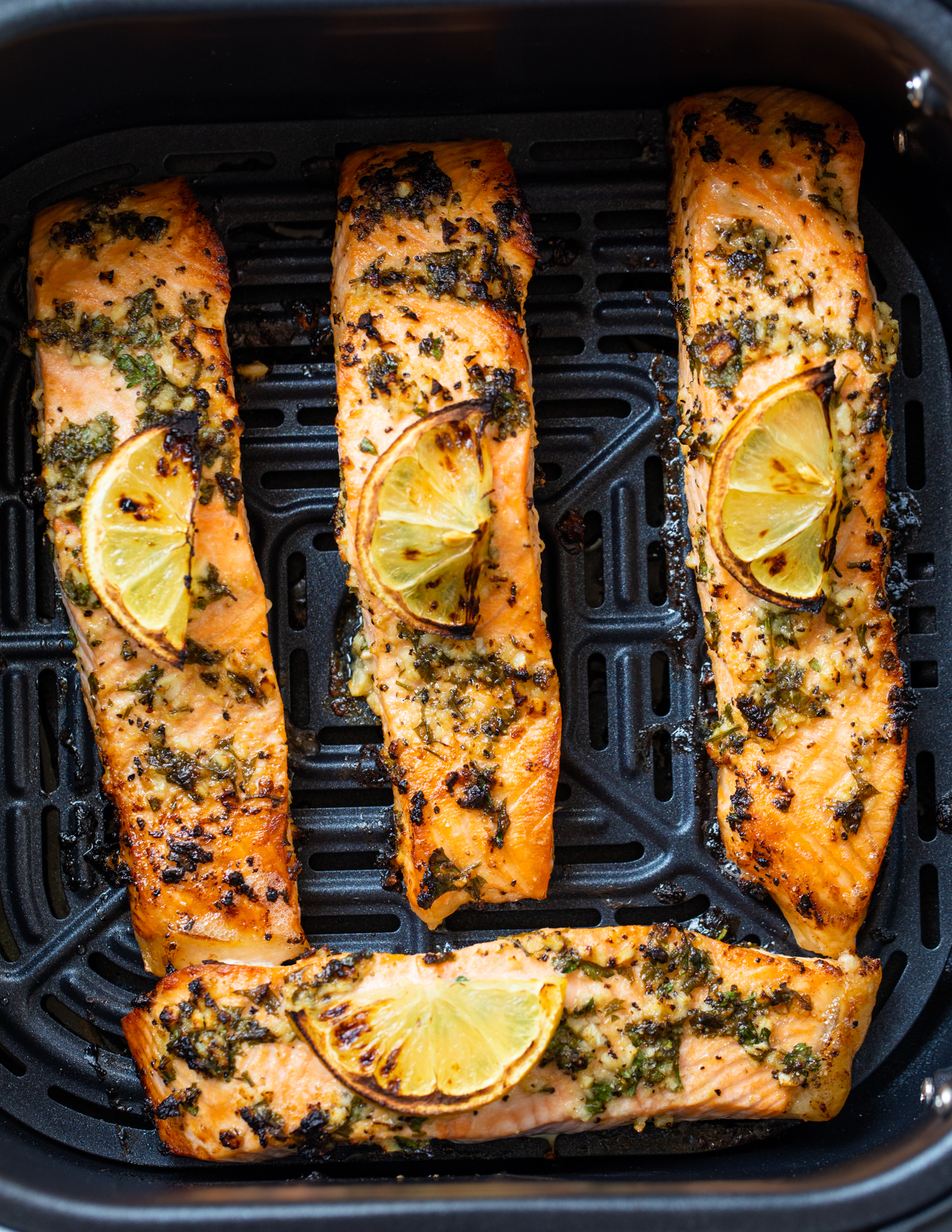 Salmon fillets cooking in an air fryer.