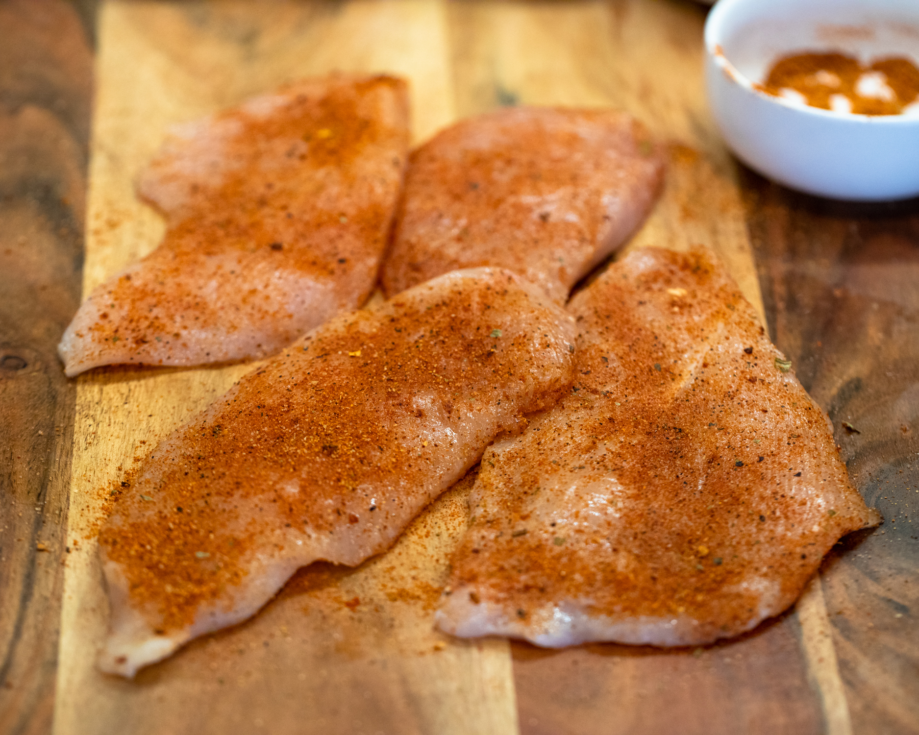 Raw seasoned chicken breast.