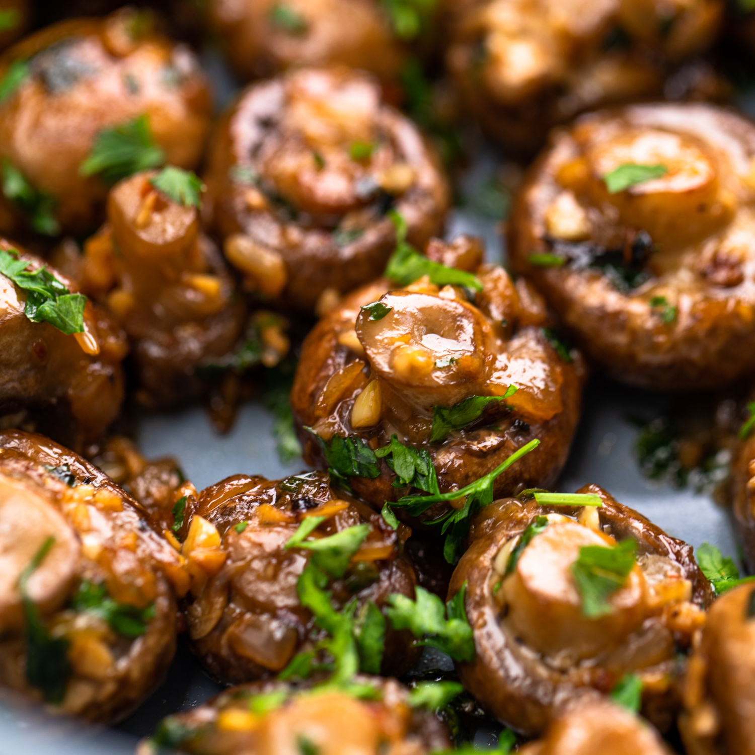 Mushrooms cooked in garlic and butter and garnished with parsley.