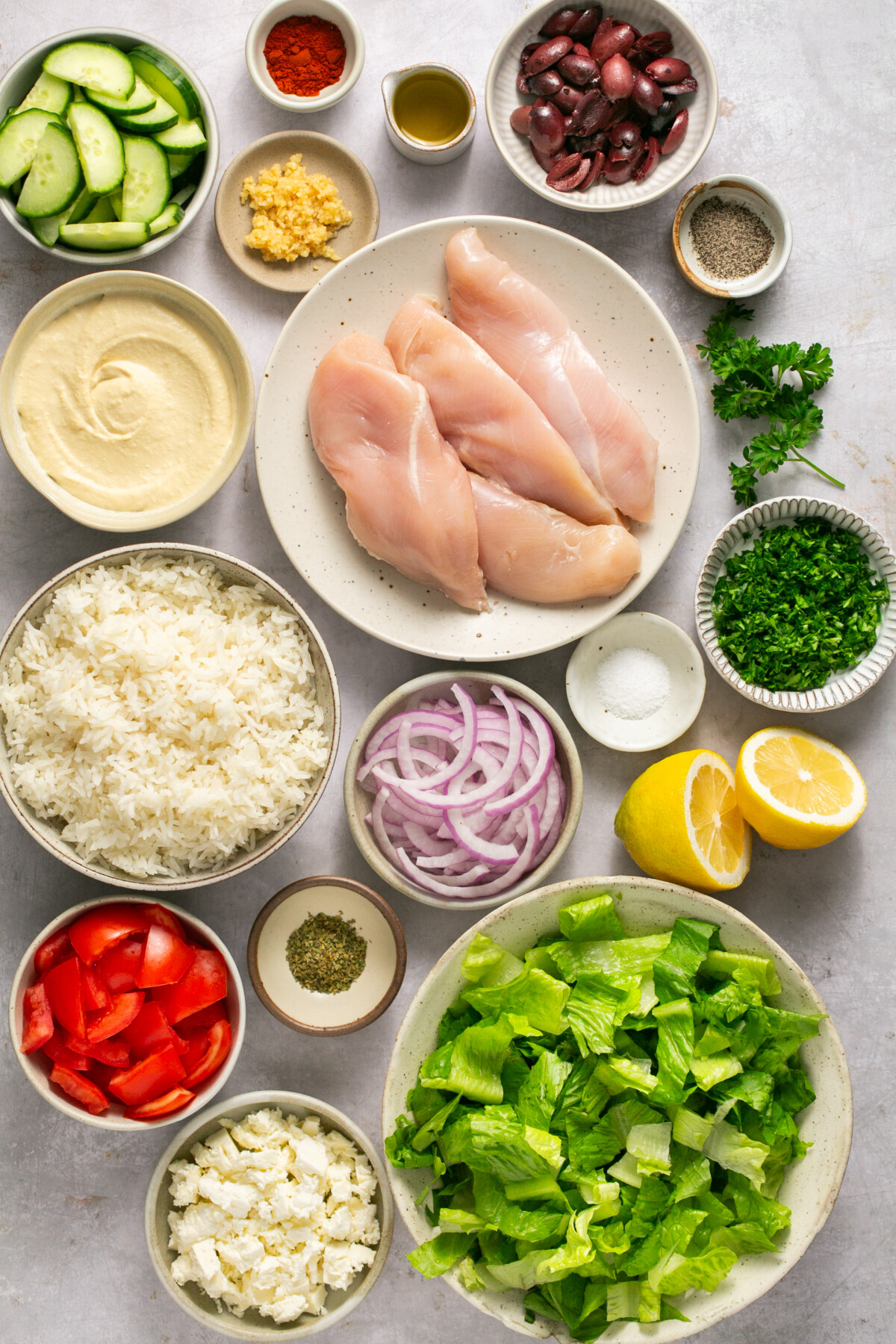 Ingredients needed for Mediterranean Chicken Bowls on a white background