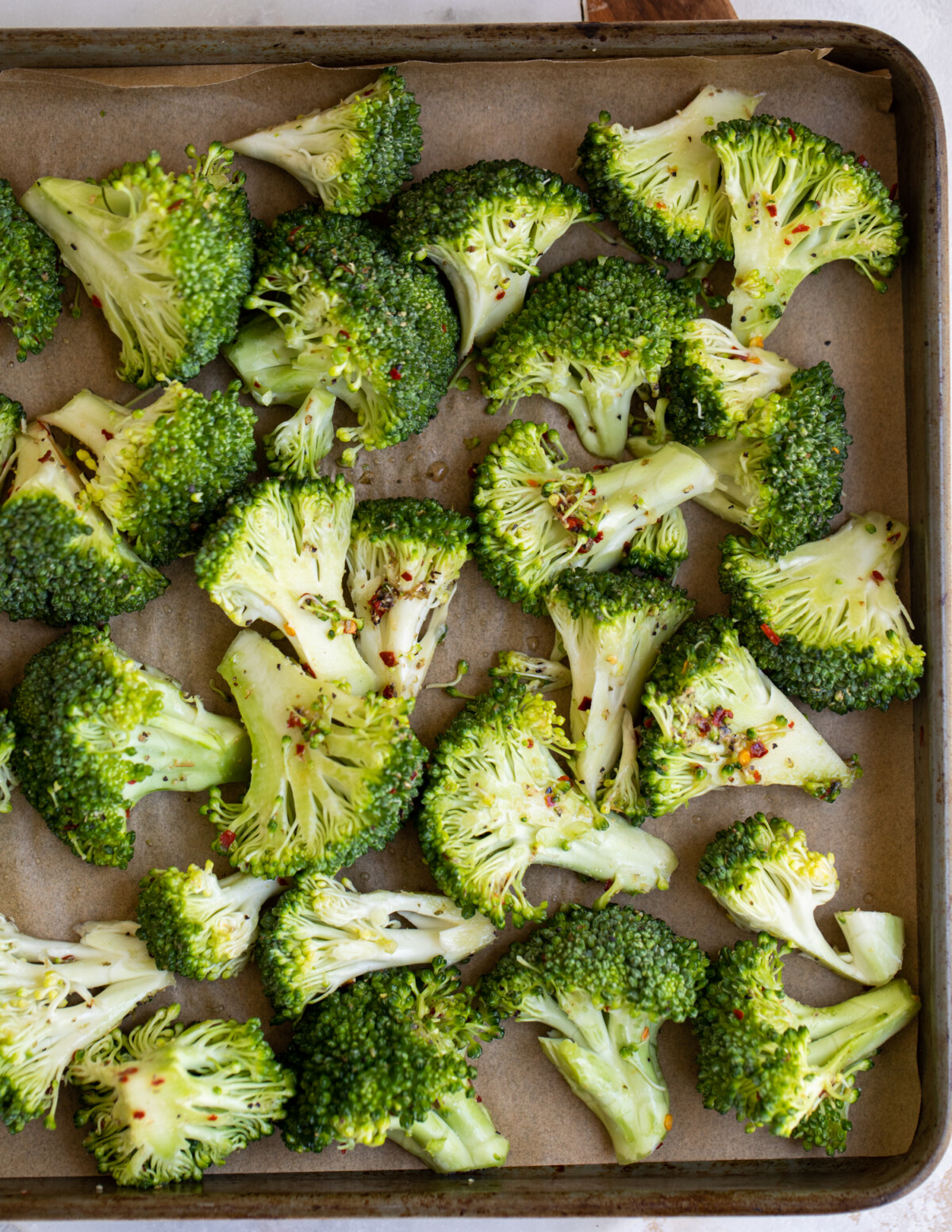 Seasoned broccoli florets on a sheet pan.